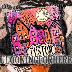 May include: A black t-shirt featuring a vibrant, hand-drawn style illustration of a town at night with orange and pink buildings, a large moon with a spiderweb, bare trees, stars, two nutcracker figures, a street lamp, and a pumpkin with the text CUSTOM.