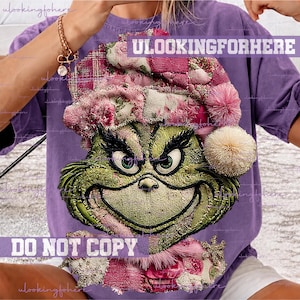 Könnte beinhalten: Ein violettes T-Shirt mit einer Grafik eines grünen Charakters mit breitem, schelmischem Grinsen, der eine rosa-weiß karierte Weihnachtsmütze mit einem flauschigen Bommel trägt. Das Design enthält den Text ULOOKINGFORHERE und DO NOT COPY.