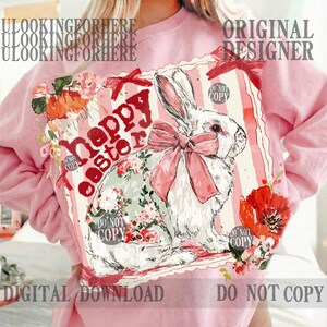 K&ouml;nnte beinhalten: Hellrosa Sweatshirt mit einem Grafikdruck. Der Druck zeigt ein wei&szlig;es Kaninchen mit einer rosa Schleife und Blumenmuster, sowie den Schriftzug "Happy Easter". Rote Blumen und Schleifen sind ebenfalls zu sehen. Die Worte "Digital Download" sind ebenfalls sichtbar.