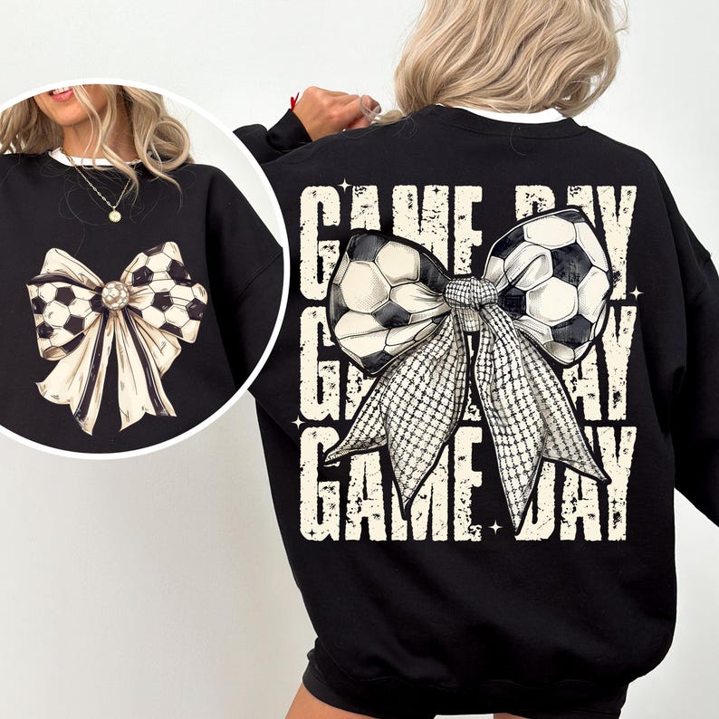 Puede incluir: Sudadera negra con un lazo de bal&oacute;n de f&uacute;tbol blanco y negro y el texto "GAME DAY" repetido tres veces.