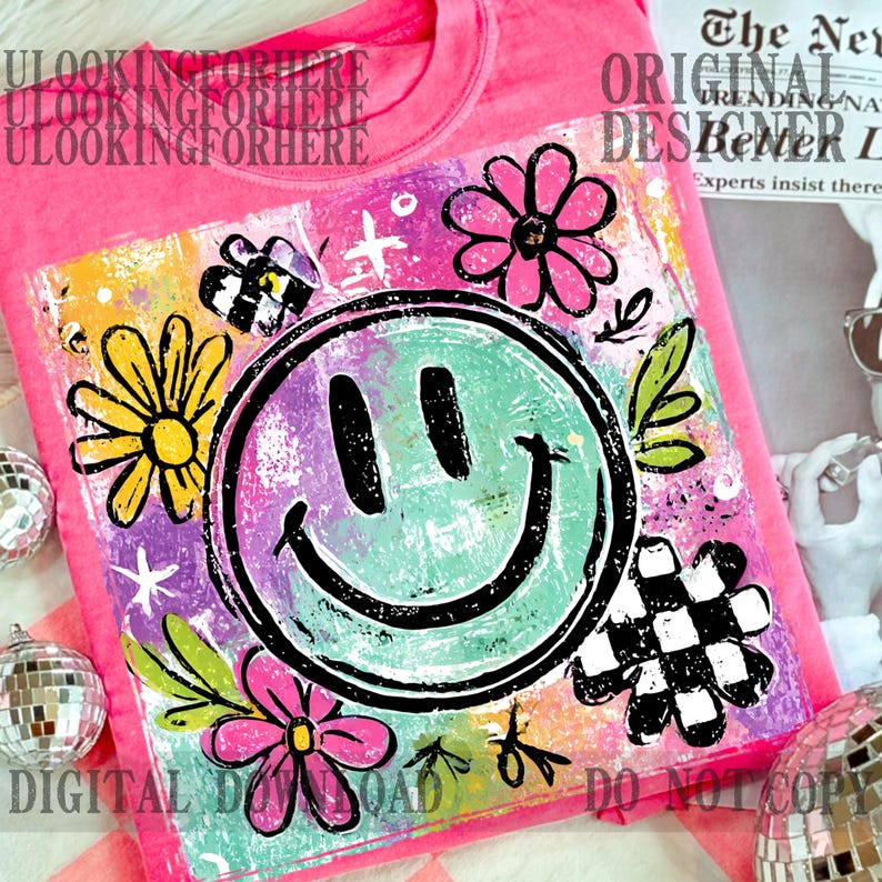 Puede incluir: Camiseta rosa brillante con un dise&ntilde;o gr&aacute;fico colorido que presenta una cara sonriente, flores y formas abstractas. Incluye el texto "DIGITAL DOWNLOAD DO NOT COPY". La camiseta tiene cuello redondo.