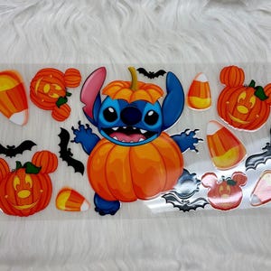 May include: A Halloween-themed sticker sheet featuring a blue cartoon character in a pumpkin costume, surrounded by orange pumpkins, candy corn, and black bats. The design has a cartoon style and is suitable for crafts.