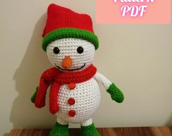 May include: White crocheted snowman amigurumi with a red hat, green trim, red scarf, and green mittens. The snowman has a carrot nose, black eyes, and red buttons.  Amigurumi Pattern PDF.