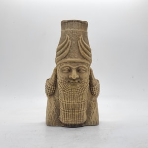 May include: A beige stone sculpture of a bearded man's head and shoulders wearing a tall, pointed hat. The sculpture has a detailed, textured surface.