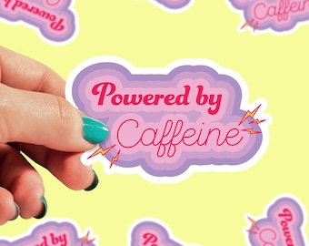 Może przedstawiać: Naklejka w kształcie fioletowej, różowej i białej chmury z tekstem "Powered by Caffeine" w różowych literach i błyskawicami po obu stronach.