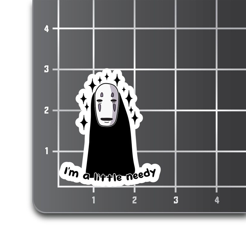 May include: A white sticker with a black and white cartoon character with a mask and the text "I'm a little needy".