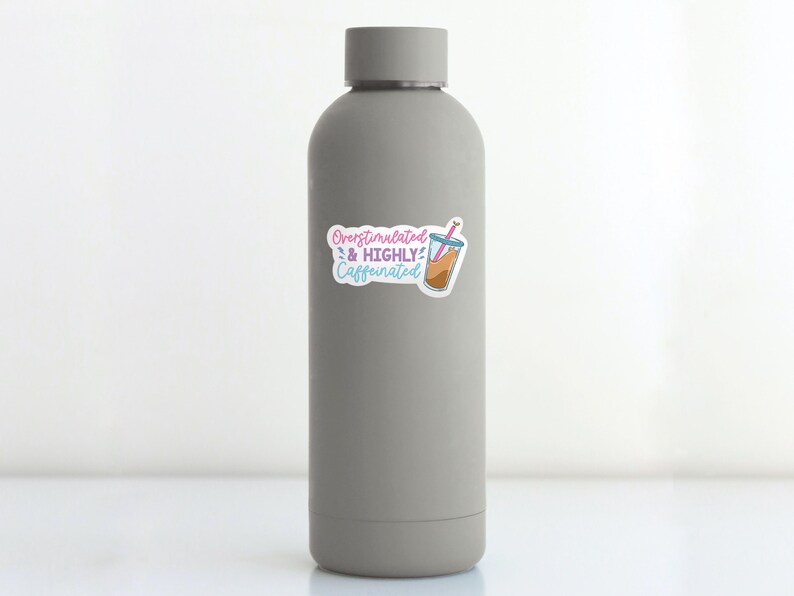May include: A gray water bottle with a sticker that says "Overstimulated & Highly Caffeinated" with a cartoon image of a glass of iced coffee with a pink straw.
