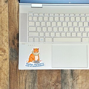 May include: A sticker of an orange cat wearing a crown and a ruff, holding an empty bowl. The sticker says "Mother, my bowl is void of nourishment."