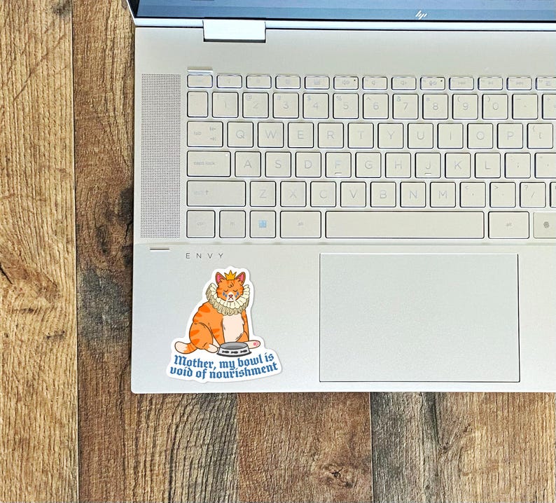 May include: A sticker of an orange cat wearing a crown and a ruff, holding an empty bowl. The sticker says "Mother, my bowl is void of nourishment."