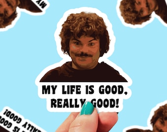 May include: A sticker featuring a smiling man with brown curly hair and a mustache. The sticker has the text "MY LIFE IS GOOD, REALLY GOOD!" in bold black letters. The background is light blue.