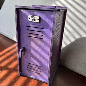 May include: A purple wooden locker with a small wooden nameplate that reads "Ms. Kim".