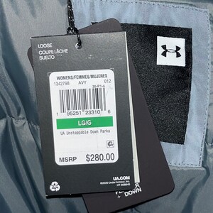 May include: A black and white tag with the Under Armour logo and text that reads "UA Unstoppable Down Parka" and "MSRP $280.00". The tag also includes a recycling symbol and the text "UA.COM ©2020 Under Armour, Inc. HT-900840 R + DOWN".