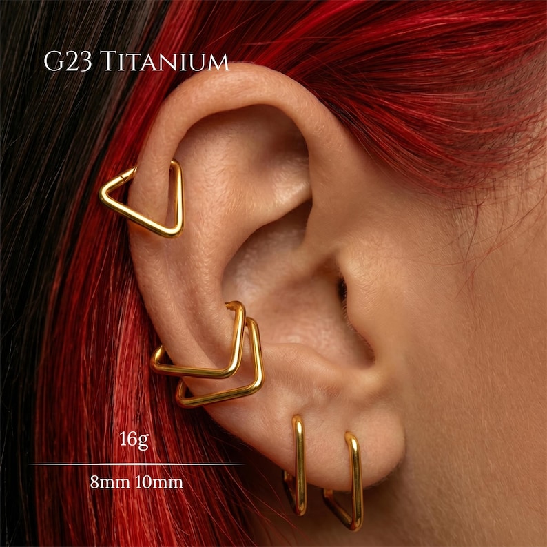 Peut inclure: Un ensemble de cr&eacute;oles triangulaires en titane G23 de couleur dor&eacute;e port&eacute;es dans plusieurs piercings d'oreille. Les bijoux sont &eacute;tiquet&eacute;s avec une &eacute;paisseur de 16g et des diam&egrave;tres de 8mm et 10mm. Finition m&eacute;tallique lisse et polie.