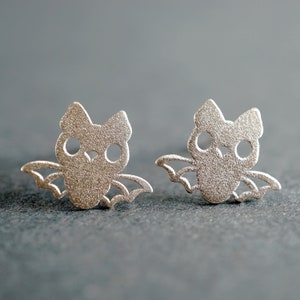 Peut inclure: Une paire de boucles d'oreilles en argent en forme de chauve-souris. Les chauves-souris sont d&eacute;coup&eacute;es et ont une finition textur&eacute;e.
