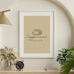 以下が含まれることがあります： ベージュの背景に、カプチーノのカップの黒の線画が描かれた額装されたプリント。カップの下には「Cappuccino COFFEE」の文字が書かれている。