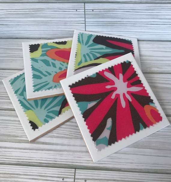 Hand-thrown ceramic coasters with a bold, stylized tropical floral design — the kind of small-batch craft object that actually looks like a real person made it.