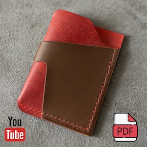 May include: A slim card holder wallet constructed from red and dark brown leather. The design features a red leather base with a dark brown leather overlay pocket, secured with visible red stitching along the edges and a curved top opening.