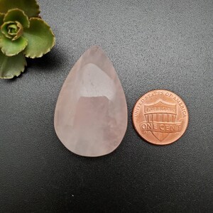 Peut inclure: Un cabochon de quartz rose en forme de larme de couleur rose pâle, d'environ la taille d'une pièce de un centime d'euro.