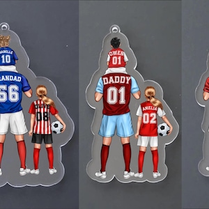 May include: Three clear acrylic ornaments featuring illustrated figures in soccer jerseys. The first shows a person with children labeled Isabelle, Jacob, and Olive. The second shows a person with children labeled Owen and Amelia. The third shows a person with a child labeled Owen.