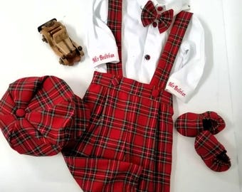 Puede incluir: Un conjunto de bebé en cuadros rojos y negros, que incluye un gorro, pantalones, camisa, pajarita y zapatos. La camisa y los pantalones tienen el nombre "Mr. Bedikian" bordado.