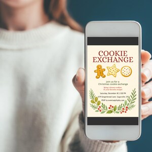 Op de afbeelding: Een smartphone toont een uitnodiging voor een "Cookie Exchange". Het ontwerp bevat peperkoek, een ster en een ronde koek. De uitnodiging bevat evenementdetails en decoratief gebladerte.