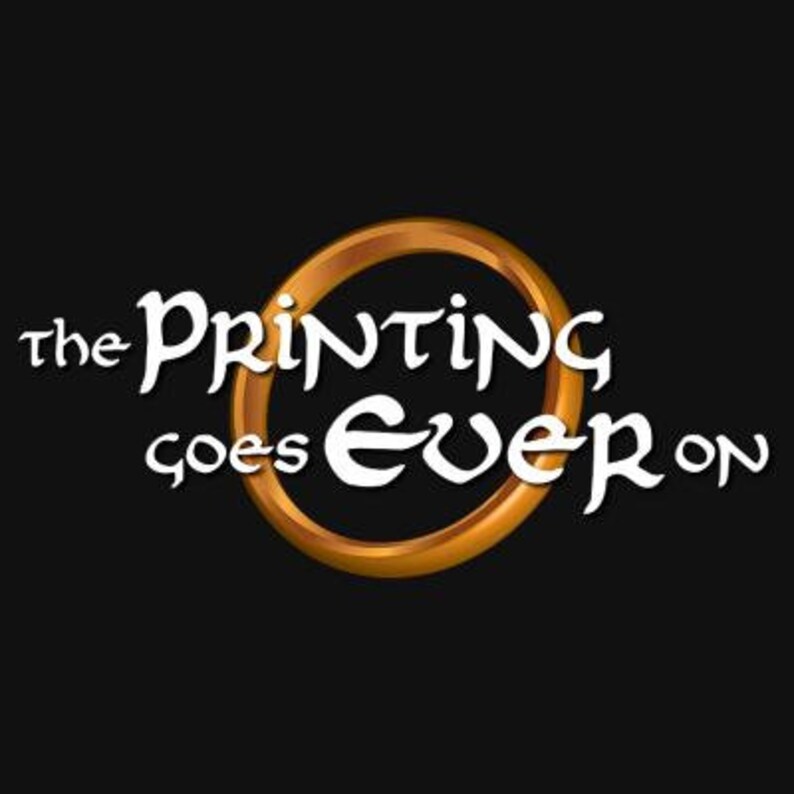 Puede incluir: Un anillo dorado con las palabras "the Printing goes ever on" en texto blanco. El anillo es una representaci&oacute;n gr&aacute;fica del Anillo &Uacute;nico de El Se&ntilde;or de los Anillos.