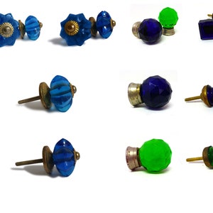 Peut inclure: Assortiment de 12 boutons de porte de placard en verre de différentes formes et couleurs, notamment vert, bleu et transparent. Les boutons ont une base en laiton et une vis pour la fixation sur une porte de placard.