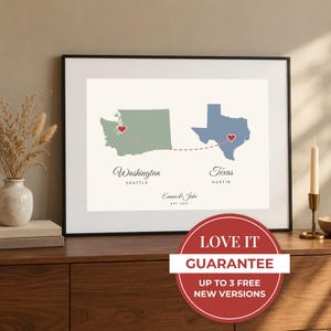 Pode incluir: Uma impressão de arte emoldurada com um mapa do estado de Washington em verde sálvia e do Texas em azul ardósia, conectados por uma linha vermelha tracejada com corações. O texto inclui Washington, Seattle, Texas, Austin e Emma & Jake, Est. 2021.