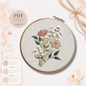 May include: An embroidery hoop with a floral design. The design features pink and peach flowers, white baby's breath, and green leaves. The text "PDF Embroidery Pattern" is in a circle at the top. The text "Beginner Friendly", "Step-by-Step Guide", and "Printable Template" are at the bottom.