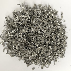 Peut inclure: Un tas de copeaux de métal argenté, probablement de l'aluminium, de formes et de tailles variées.