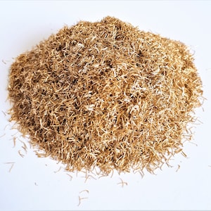 Peut inclure: Un tas de petits copeaux de métal dorés, possiblement en laiton ou en bronze, sur fond blanc. Les copeaux finement coupés créent une texture dense. Ce matériau pourrait servir à l'artisanat ou à la décoration.