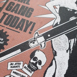 Puede incluir: Un p&oacute;ster de estilo vintage con una ilustraci&oacute;n en blanco y negro de una mujer sosteniendo un cuchillo. El p&oacute;ster tiene un fondo rosa y el texto "Local Girl Gang Today!" en negro. El p&oacute;ster tambi&eacute;n presenta una calavera y varias cajas peque&ntilde;as con texto que dice "Jiu Jitsu Karate", "Boxing", "Wrestling", y "Feats of Strength".