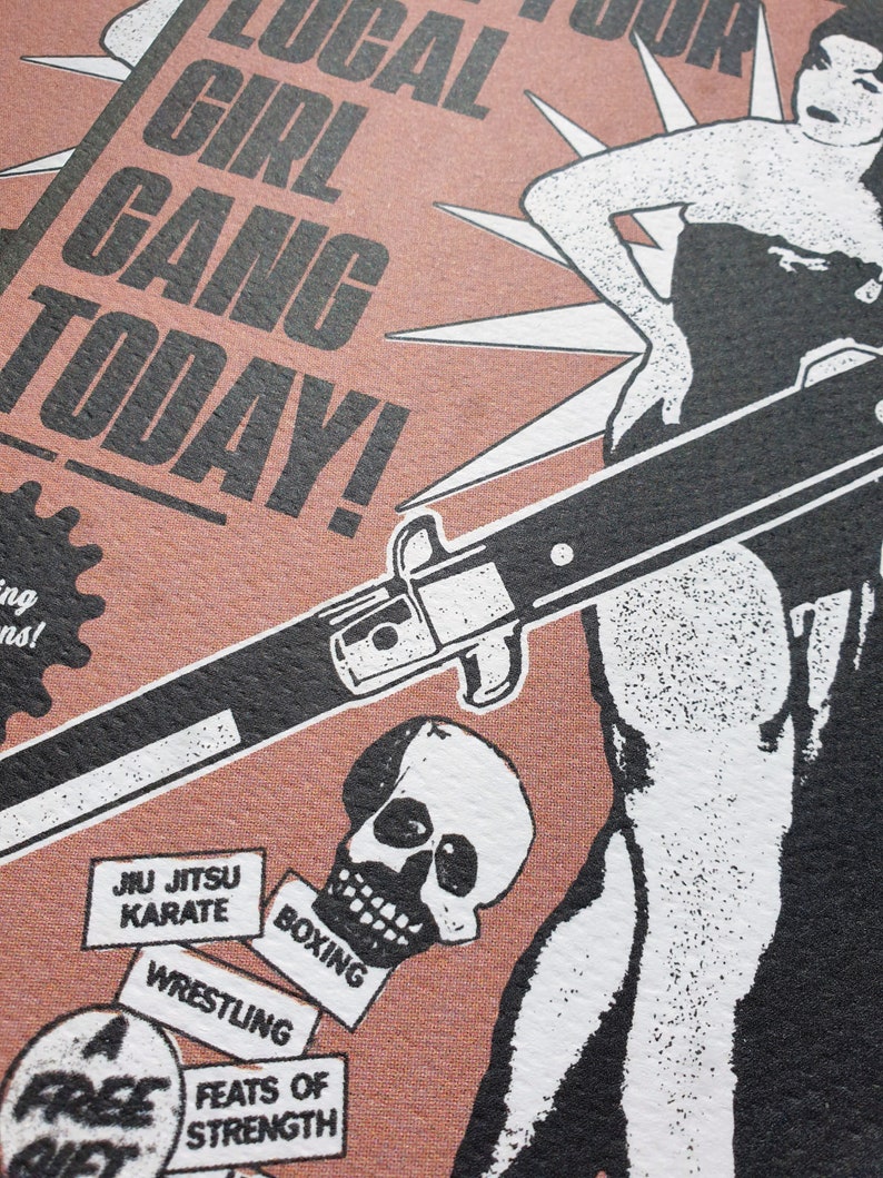 Puede incluir: Un p&oacute;ster de estilo vintage con una ilustraci&oacute;n en blanco y negro de una mujer sosteniendo un cuchillo. El p&oacute;ster tiene un fondo rosa y el texto "Local Girl Gang Today!" en negro. El p&oacute;ster tambi&eacute;n presenta una calavera y varias cajas peque&ntilde;as con texto que dice "Jiu Jitsu Karate", "Boxing", "Wrestling", y "Feats of Strength".