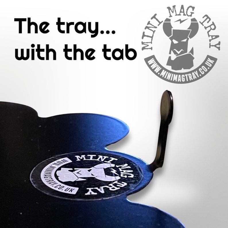 May include: Black tray with a tab, featuring the text "The tray... with the tab". The tray has a unique shape and a sticker with the words "Mini Mag Tray" and a website address. The logo is a stylized figure.