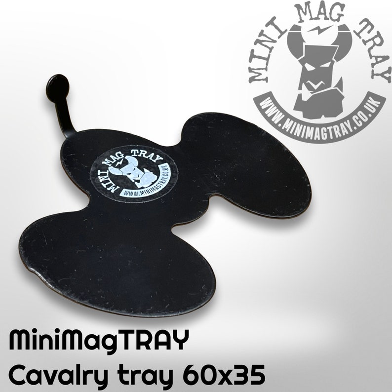 Puede incluir: Bandeja Cavalry de metal negro con una forma &uacute;nica y un peque&ntilde;o asa. La bandeja tiene una pegatina con el logotipo de MiniMagTRAY y el texto "Cavalry tray 60x35". La bandeja mide aproximadamente 60 cm por 35 cm.