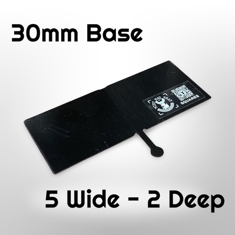 Puede incluir: Base rectangular negra con una base de 30 mm, 12,7 cm de ancho y 5,1 cm de profundidad. La base tiene una peque&ntilde;a pesta&ntilde;a con un extremo circular. Una pegatina con texto y un c&oacute;digo QR est&aacute; en la base.