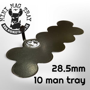 May include: A black metal tray with a unique, multi-lobed design. The tray is labeled "10 man tray" and measures 28.5mm. The Mini Mag Tray logo is visible, along with the website address. The tray is designed to hold small items.
