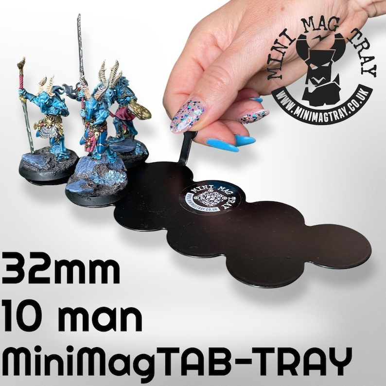 May include: A black MiniMagTAB-TRAY holds three miniature figurines. The tray is held by a hand with long, blue fingernails. The figurines are blue and gold, with detailed armor. Text on the tray reads "32mm 10 man MiniMagTAB-TRAY".