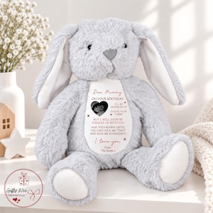May include: A light gray plush bunny with long ears and a white patch on its chest. The patch features a black and white ultrasound image and text that reads: Dear Mummy ON YOUR BIRTHDAY I'LL BE SNUGGLED UP INSIDE YOUR TUMMY BUT I WILL SOON BE CUDDLED UP WITH YOU HUG THIS BUNNY UNTIL YOU CAN HOLD ME TIGHT AND KISS ME GOODNIGHT I love you From The Bump x.