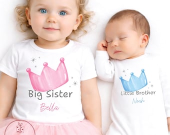May include: White t-shirts and onesie with crown graphics. The t-shirt says "Big Sister Bella" with a pink crown. The onesie says "Little Brother Noah" with a blue crown. The little girl is wearing a pink tutu.