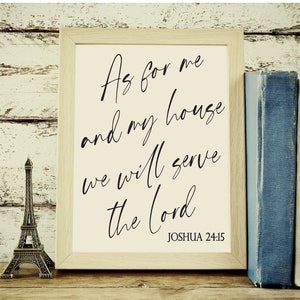 May include: A framed print with a white background and black cursive text that reads "As for me and my house we will serve the Lord" with the scripture reference "Joshua 24:15" below the text.