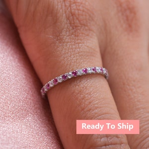 Op de afbeelding: Een delicate eeuwigheidsring met afwisselende roze en witte edelstenen. De ring is gezet in zilver.