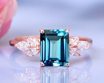 Anillo de topacio azul Londres de talla esmeralda con detalles de diamantes marquesa en oro de 14 quilates.