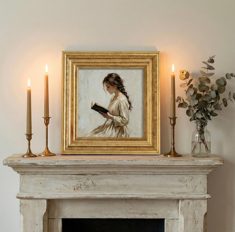 May include: A framed painting of a woman reading, with a gold frame, sits on a distressed white mantel. Lit candles in brass holders flank the painting. A vase of greenery is to the right.