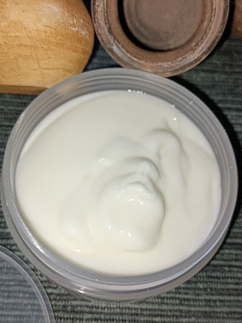 Op de afbeelding: Een witte, romige substantie in een doorzichtige plastic container. De substantie heeft een gladde, gelijkmatige textuur en lijkt dik en viskeus.