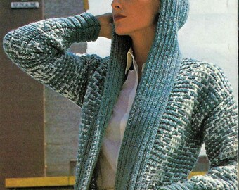 May include: A long, teal and white knitted cardigan with a hood. The cardigan has a shawl collar and pockets.