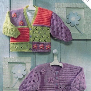 Puede incluir: Dos cárdigans de punto para niños, uno con un diseño de patchwork en verde, rosa y naranja, y el otro en morado sólido. Ambos cárdigans presentan adornos florales.