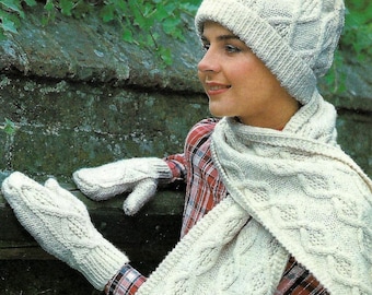 May include: A white knitted hat, scarf, and mittens set with a cable knit pattern. The hat has a folded brim and the scarf has fringe.