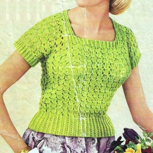 May include: A vintage illustration of a woman wearing a lime green knitted top with a square neckline and short sleeves. The top has a textured pattern and a fitted waist. She is also wearing a patterned skirt and a gold bracelet.