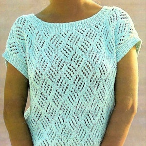 Puede incluir: Una blusa de crochet azul claro con un patrón de chevron y mangas cortas.